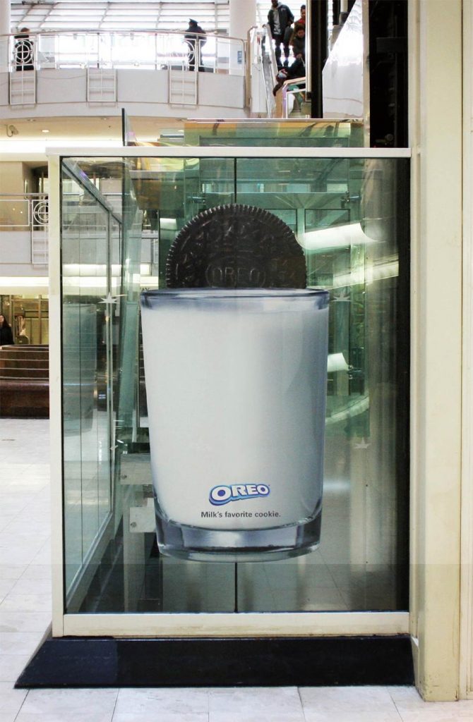 Čokoladni Oreo keks do pola u čaši mleka - reklamiranje firme
