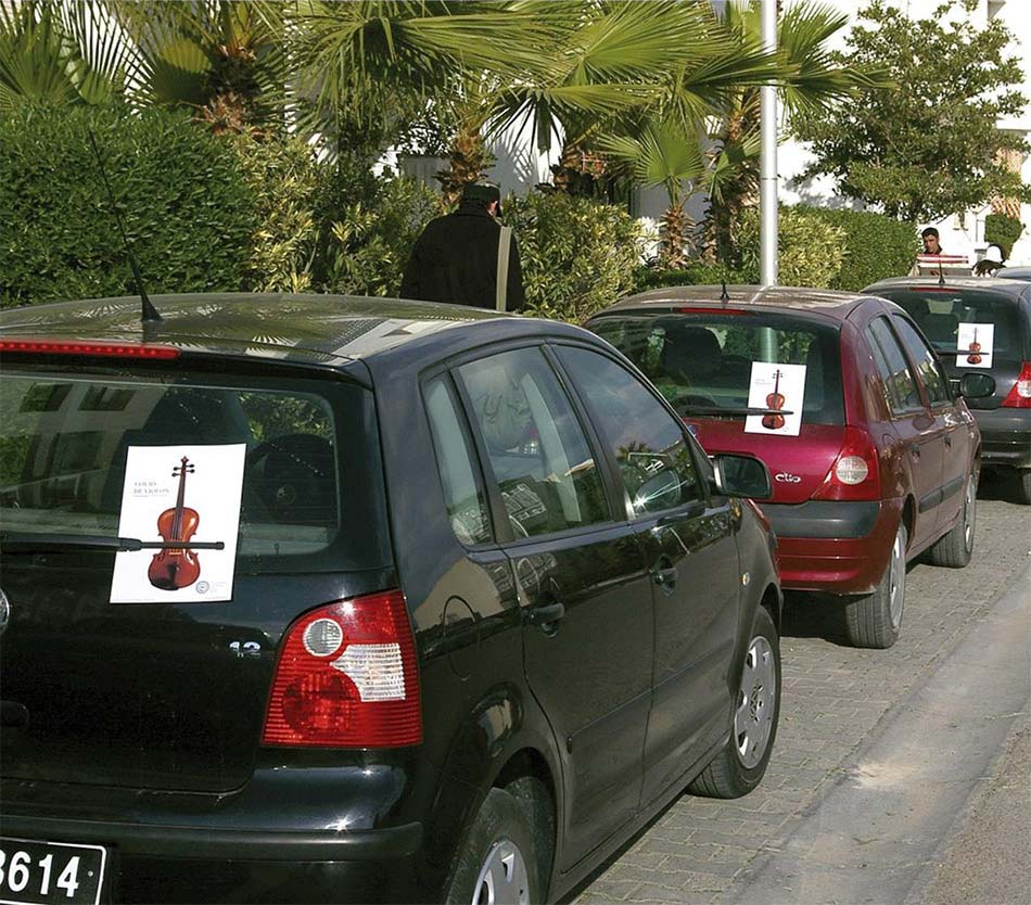 Flajeri na zadnjim staklima auta parkiranih pored zelene bašte - reklamiranje CMIJ