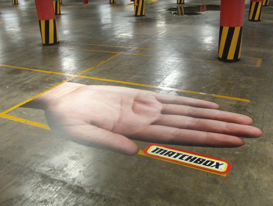 Poster ogromne šake i Matchbox plakat na parkingu u garaži - reklamiranje brenda
