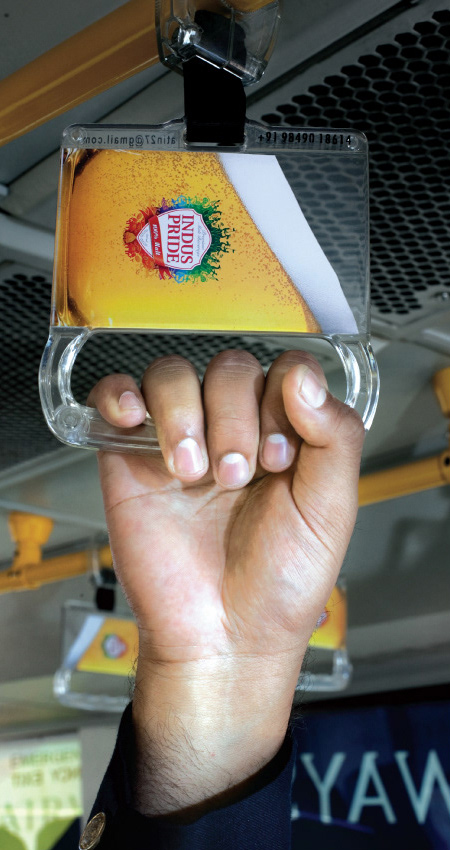 Putnik u busu se drži za plastičnu ručku rukohvat kriglu piva - reklamiranje firme-SABMiller