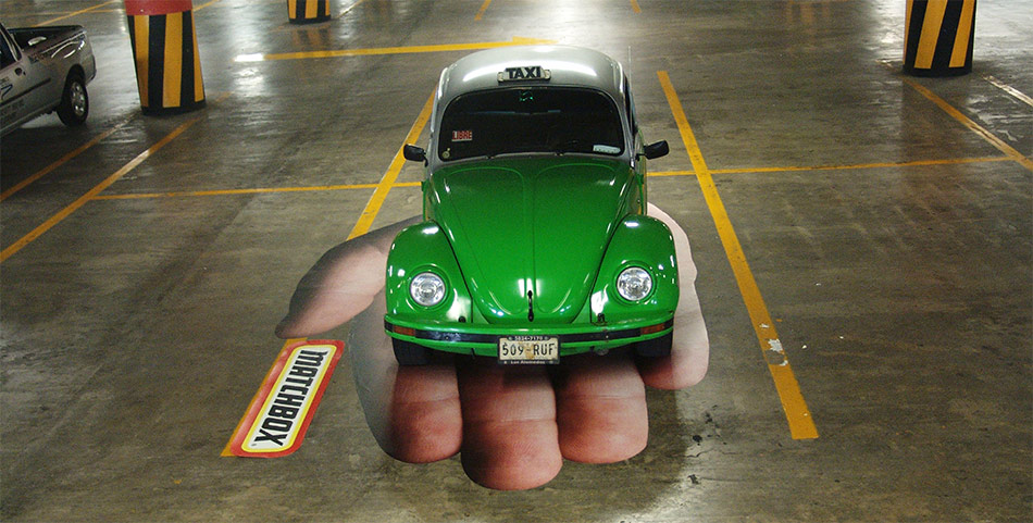 Zelena Buba na dlanu ogromne šake parking mesta u garaži - Matchbox reklamiranje